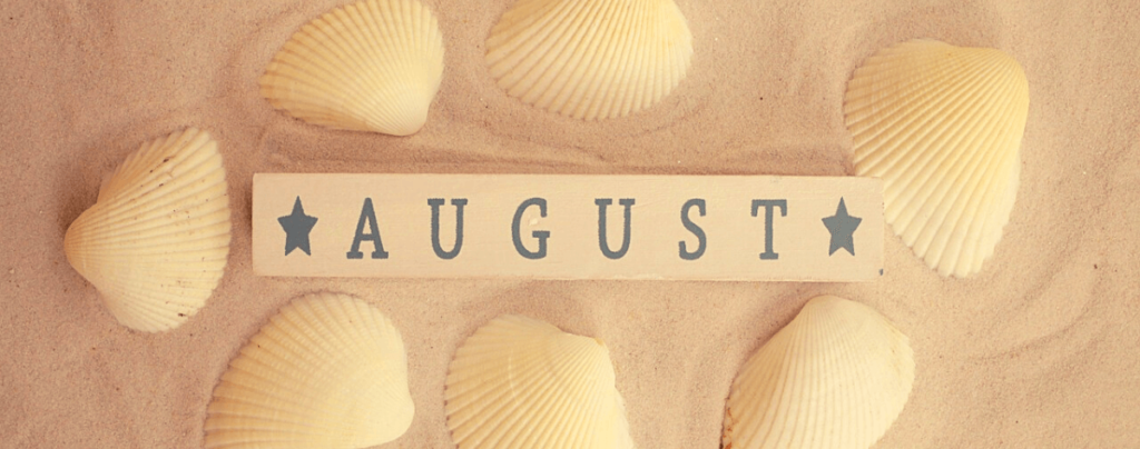Word "August" written in a piece of wood in a beach in Barcelona